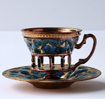 青い花柄の胴に、金と茶の柱を付けたカップ＆ソーサー